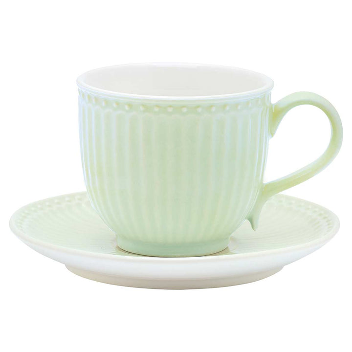 Eine hellgrüne GreenGate - Alice Teetasse aus Keramik mit passender Untertasse und geripptem Design.