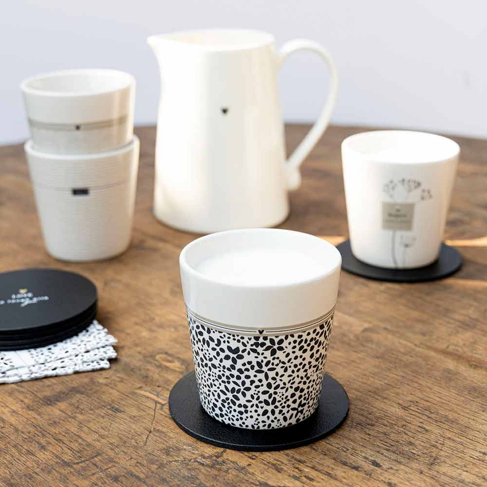 Eine Reihe von Bastion Collections – Becher Wild Flower Tassen und Untersetzer auf einem Holztisch.