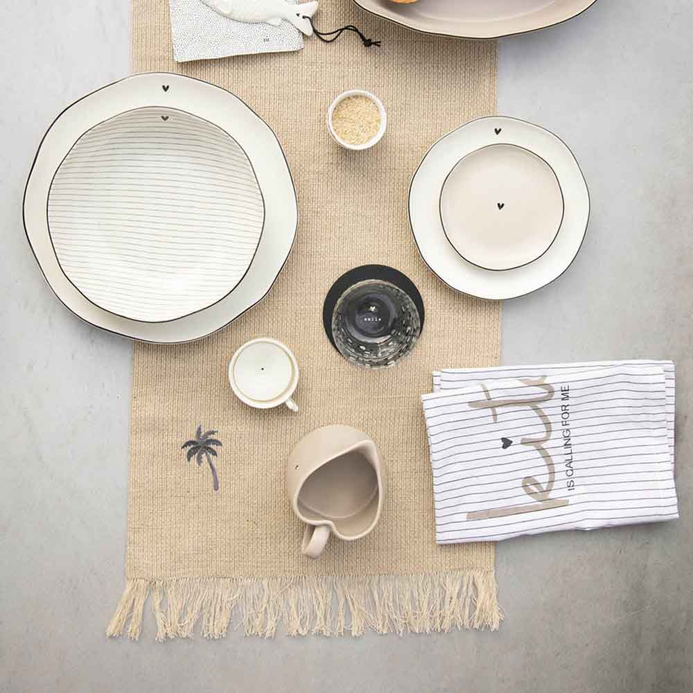 Ein Tisch mit Bastion Collections – Dessertteller Herz, Schüsseln und Utensilien.