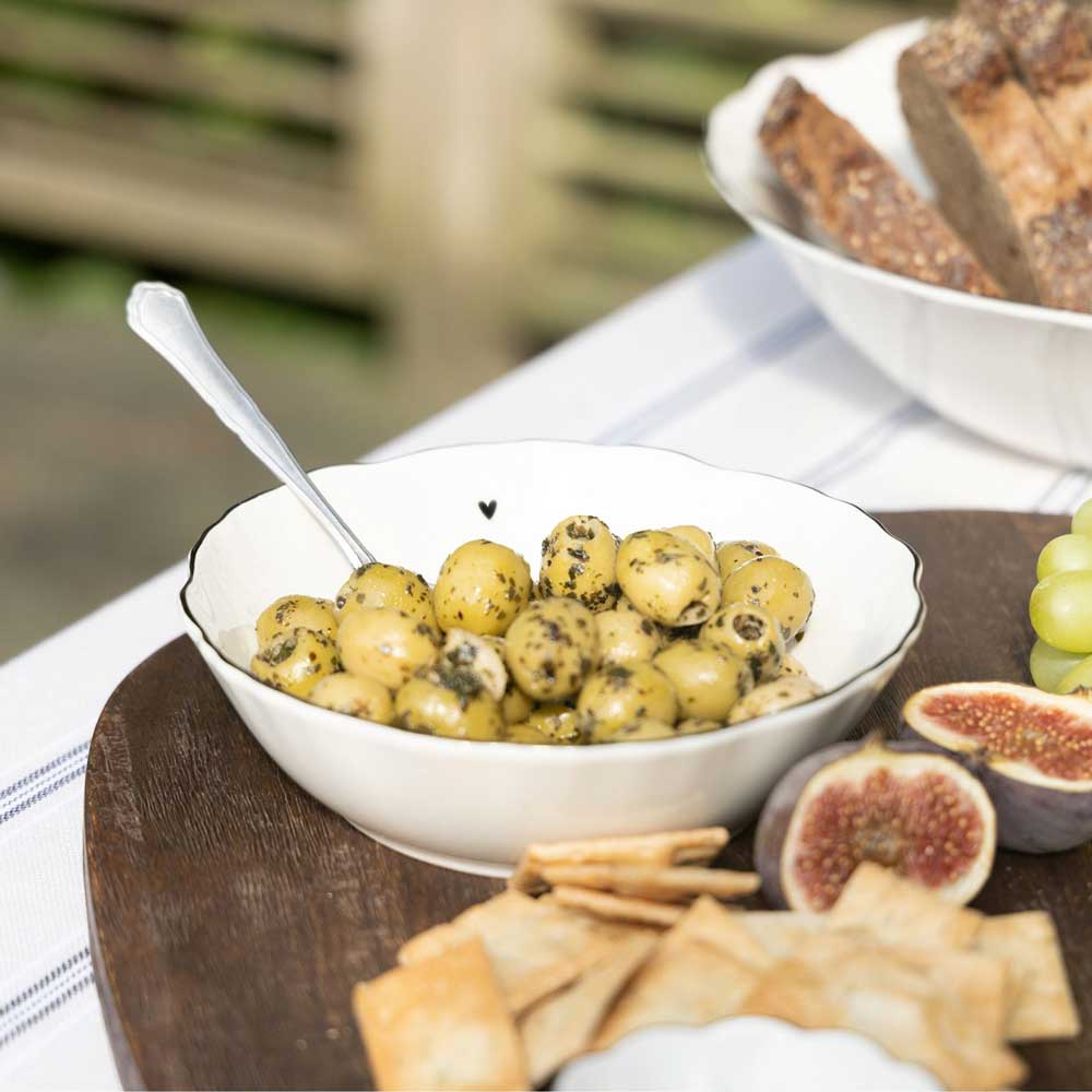 Oliven und Feigen auf einer Bastion Collections – Schüssel Herz mit Crackern und Weintrauben.