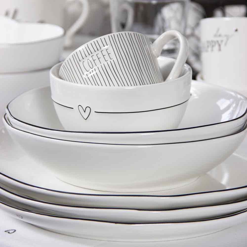 Ein Satz Bastion Collections – Suppenteller Herz Teller und Tassen auf einem Tisch.