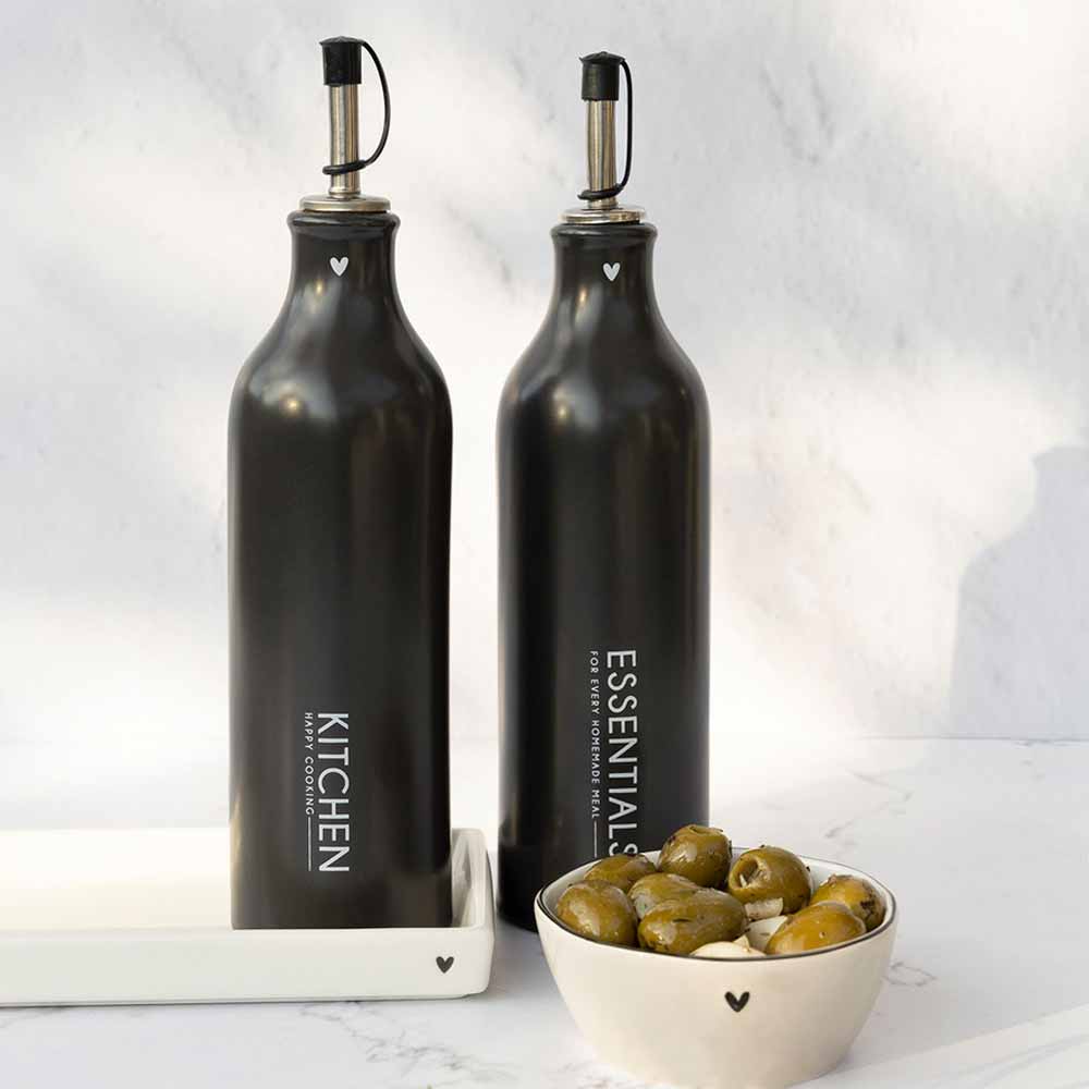 Eine schwarze Flasche mit Oliven und einer Schüssel auf den Bastion Collections – Tablett rechteckig Herz weiß.