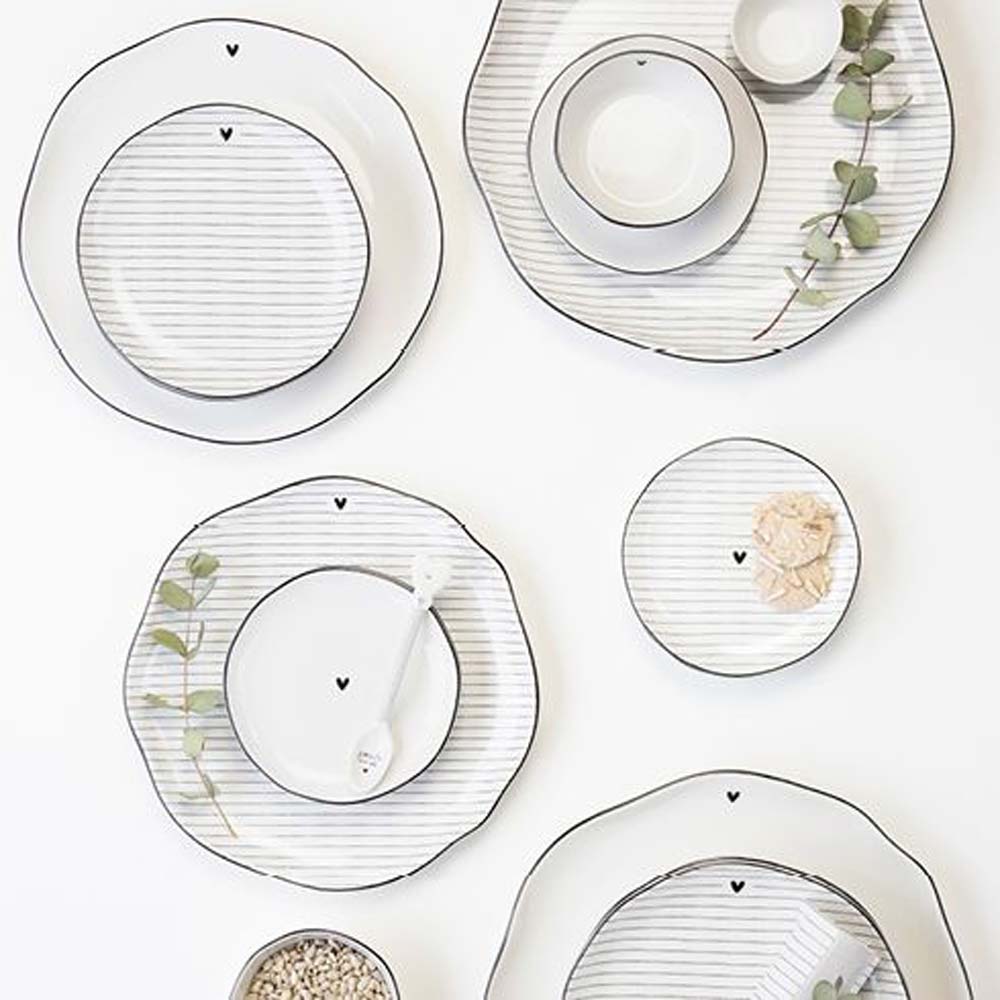 Ein Set der Bastion Collections – Dessertteller Herz mit Streifen mit schwarz-weißem Streifenmuster.