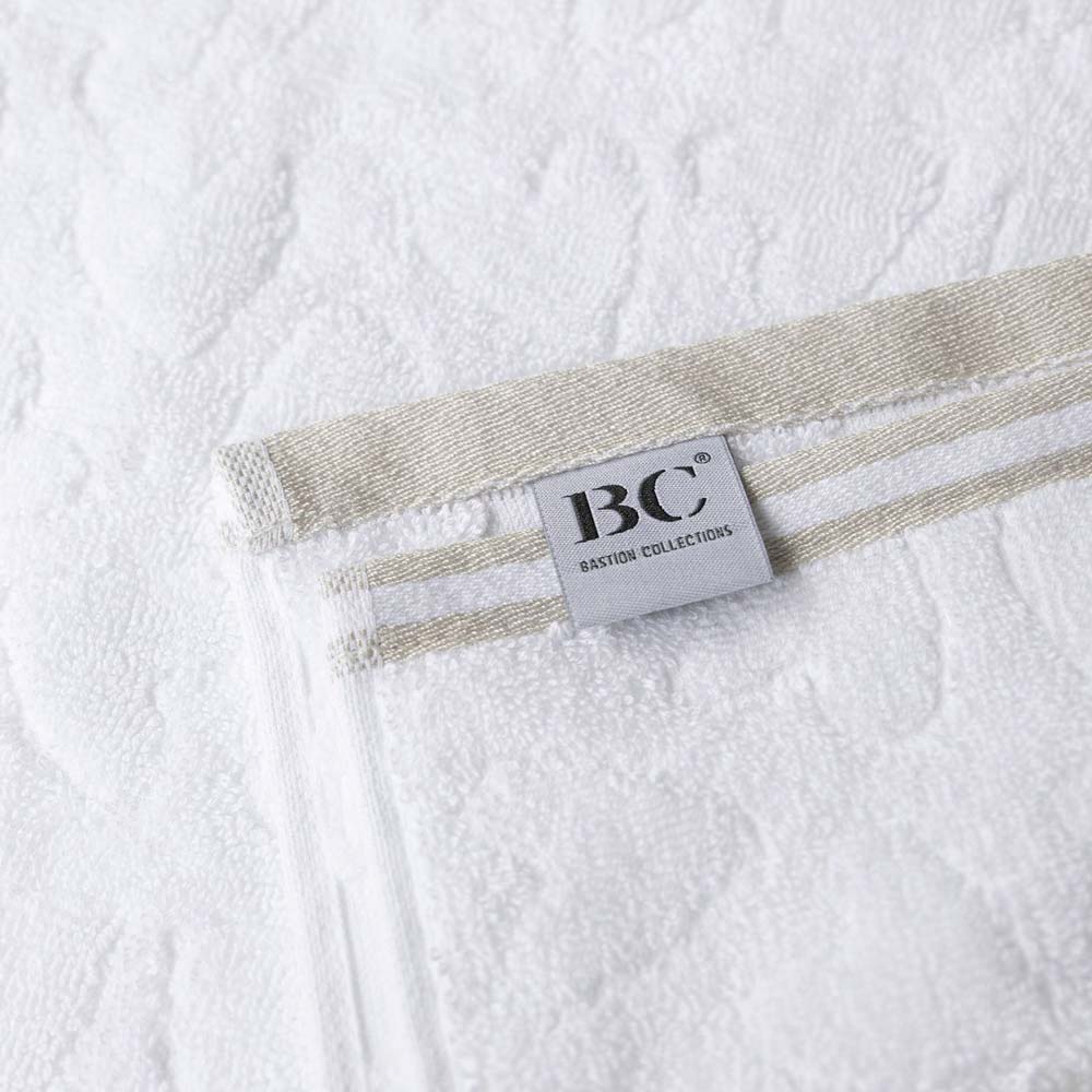 Ein weißes Handtuch mit dem Wort Bastion Collections – Gästehandtuch Weiß Beige 55 x 30 cm darauf.