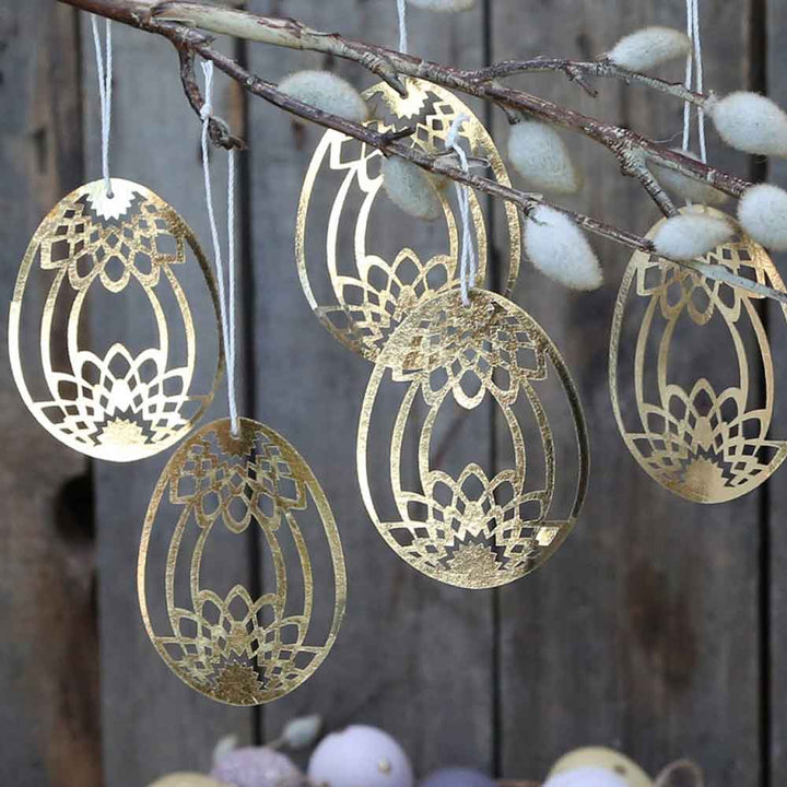 Chic Antique - Osterei Scherenschnitt Gold 5er-Set, lasergeschnittene Ostereierdekorationen, die an einem Ast hängen.