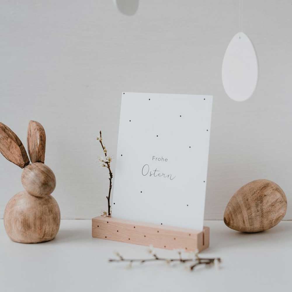 Ein Eulenschnitt - Postkarte Frohe Ostern Halter mit einem Holzhasen und einem Holzhasen.