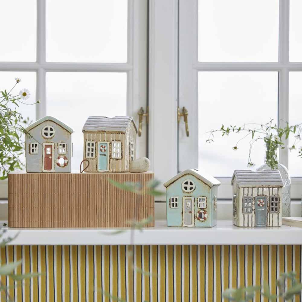 Dekorative Miniaturhäuser von Ib Laursen auf einer Fensterbank.