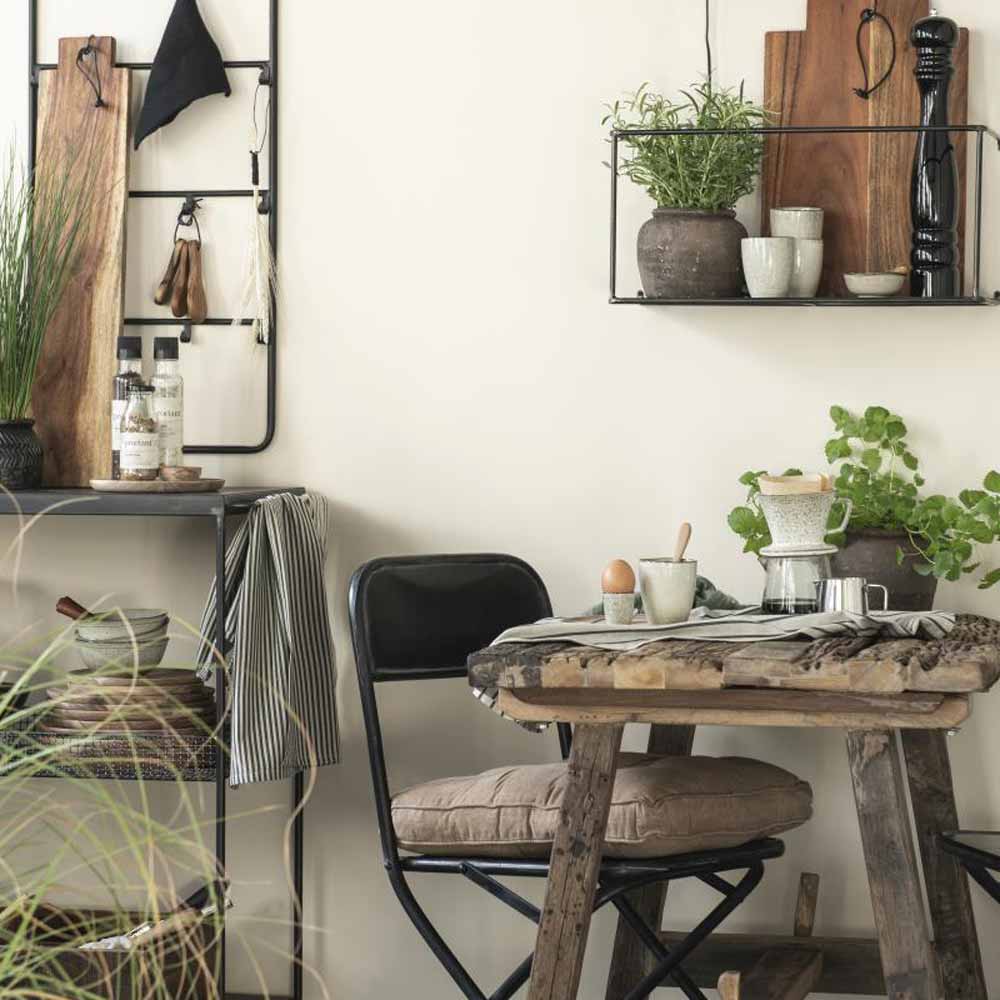 Gemütliche Küchenecke mit rustikalem Holztisch, schwarzen Metallstühlen und Regalen mit Ib Laursen - Eierbecher Sand Dunes und Küchenutensilien.