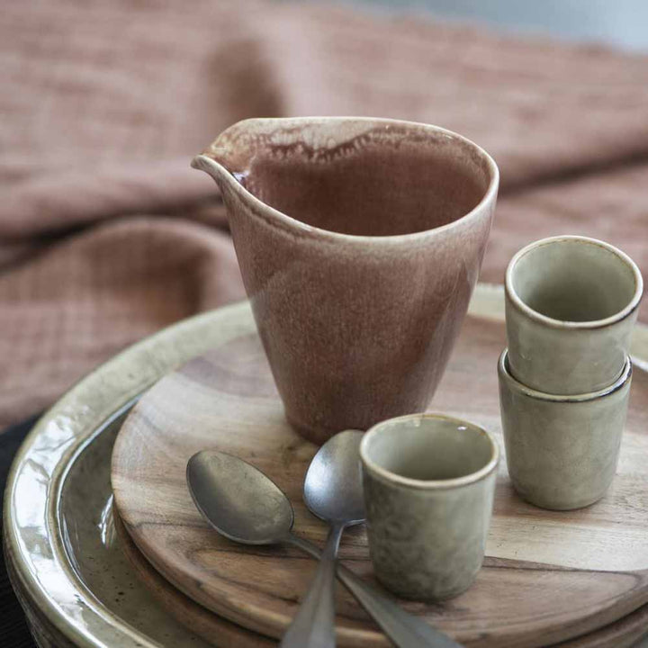 Keramik Ib Laursen - Eierbecher Sand Dunes Krug und Tassen auf einem Teller mit einem Löffel, gedeckt auf einem Tisch mit einer braunen Tischdecke.