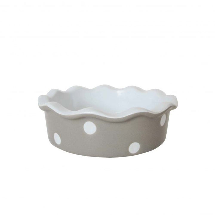 Eine beige Keramik-Kuchenform mit gewelltem Rand und weißen Punkten auf einem isolierten weißen Hintergrund. Isabelle Rose – Tarteform mit Punkten.