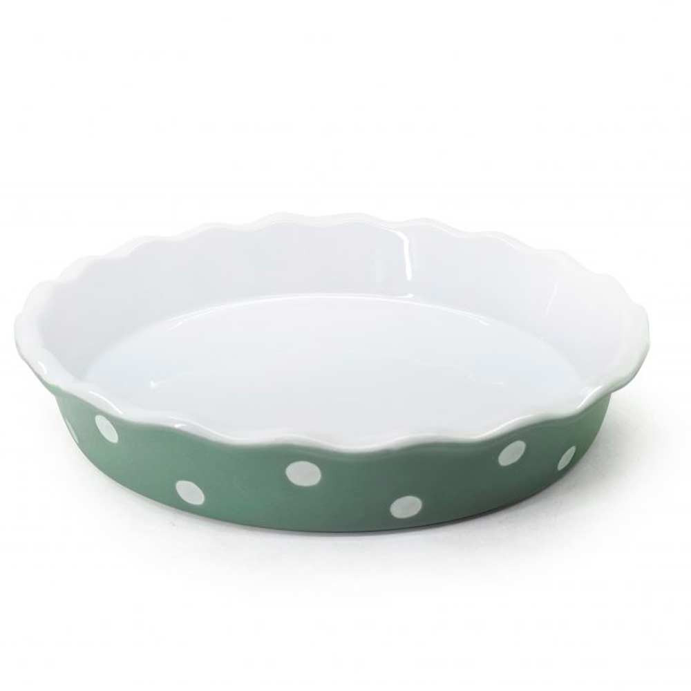 Isabelle Rose – Grüne Kuchenform aus Keramik mit weißen Punkten und gewelltem Rand, isoliert auf weißem Hintergrund.