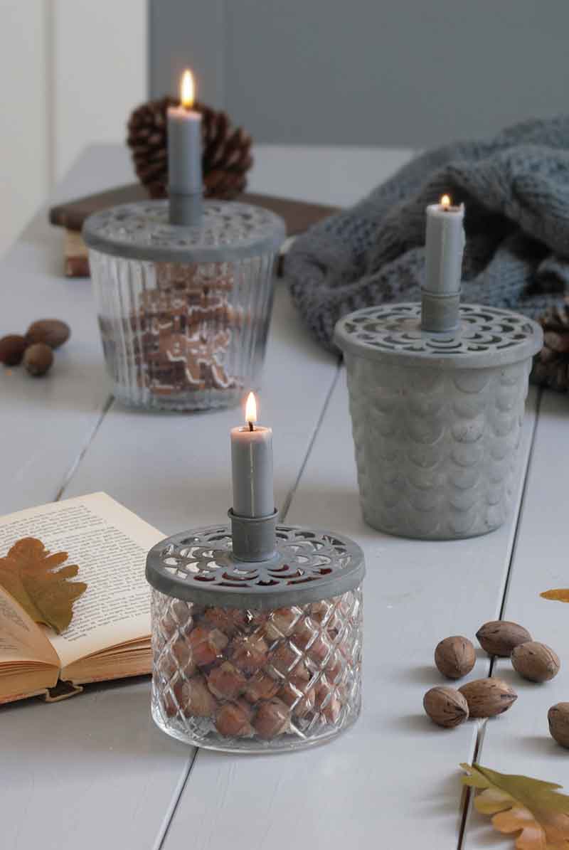 Drei Krasilnikoff - Glasvasen für Kerzen und Deko auf einem Tisch, begleitet von einem Buch mit Herbstblättern, einer kuscheligen Decke und verstreuten Nüssen.