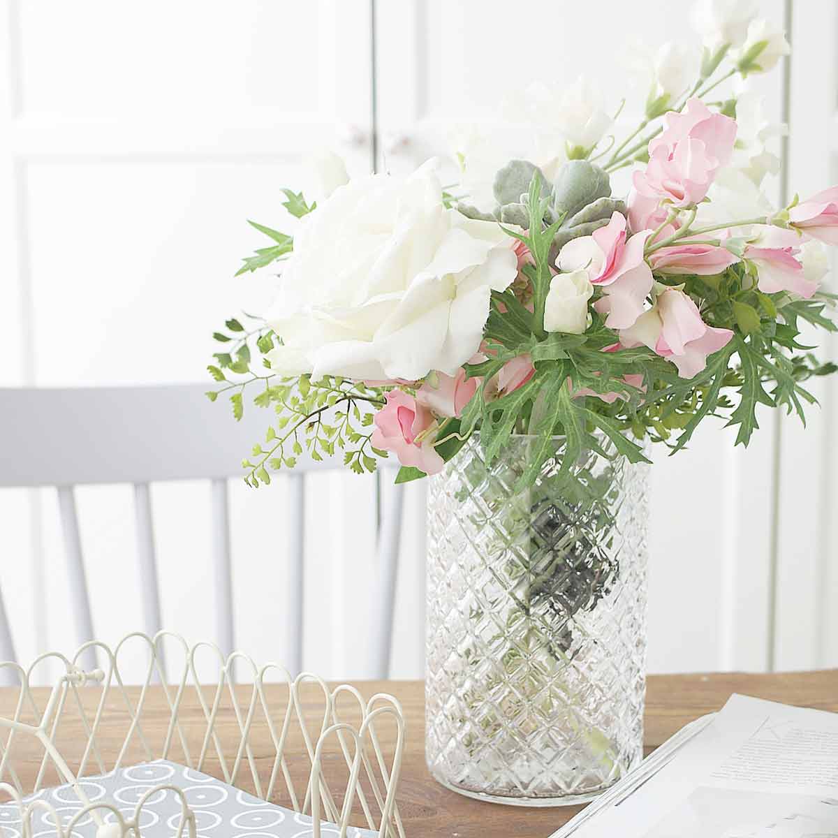 Eine Vase von Krasilnikoff - Windlicht Glas Karo groß auf einem Holztisch neben einem Fenster.