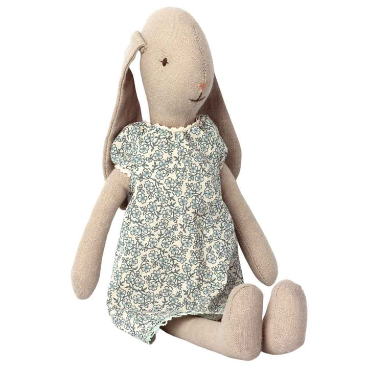 Ein Maileg - Kleidung für Hase Bunny Nachthemd Größe 2 in einem geblümten Kleid, aufrecht sitzend mit zur Seite hängenden Ohren.