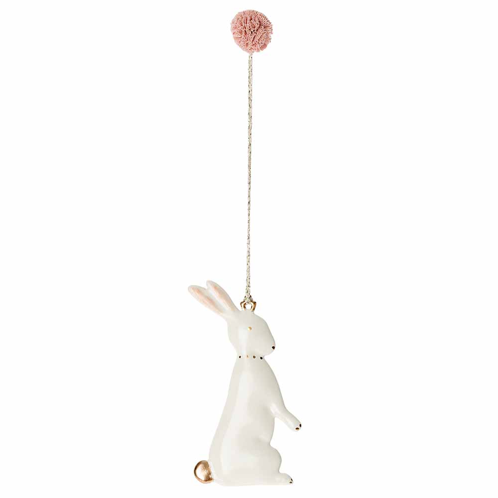 Eine Maileg - Osterhase Metallanhänger Luna-Figur, die auf ihren Hinterbeinen steht und zu einer rosafarbenen Kugel greift, die an einer Kette hängt.