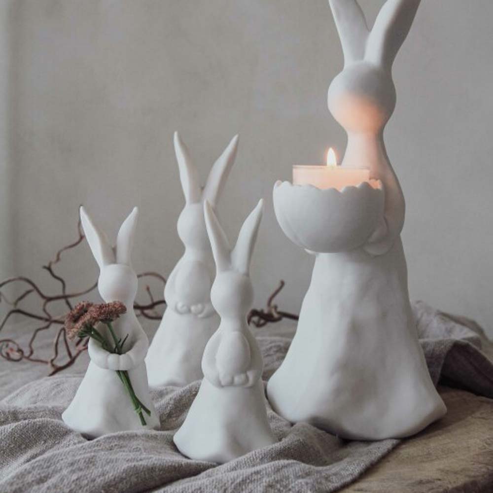 Eine Gruppe weißer Kaninchen mit einem Majas Cottage - Hase mit Ei für Teelicht.