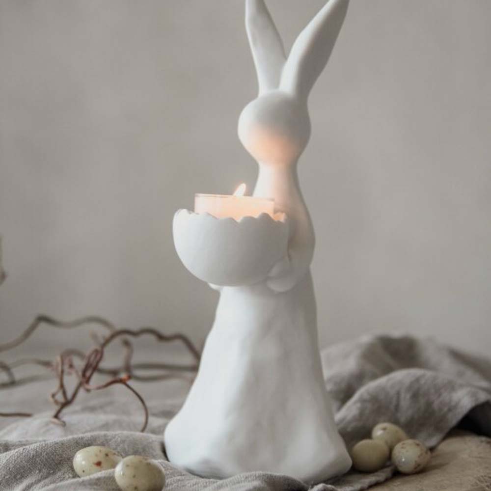 Eine Majas Cottage - Hase mit Ei für Teelicht-Statue mit einer Kerze.