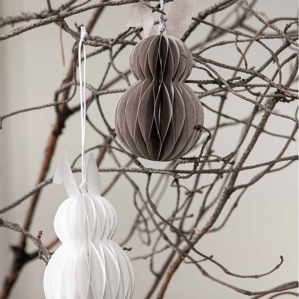 Storefactory - Hilma Anhänger Osterhase Papier braune Ornamente hängen an kahlen Zweigen und schaffen eine minimalistische Weihnachtsdekoration.