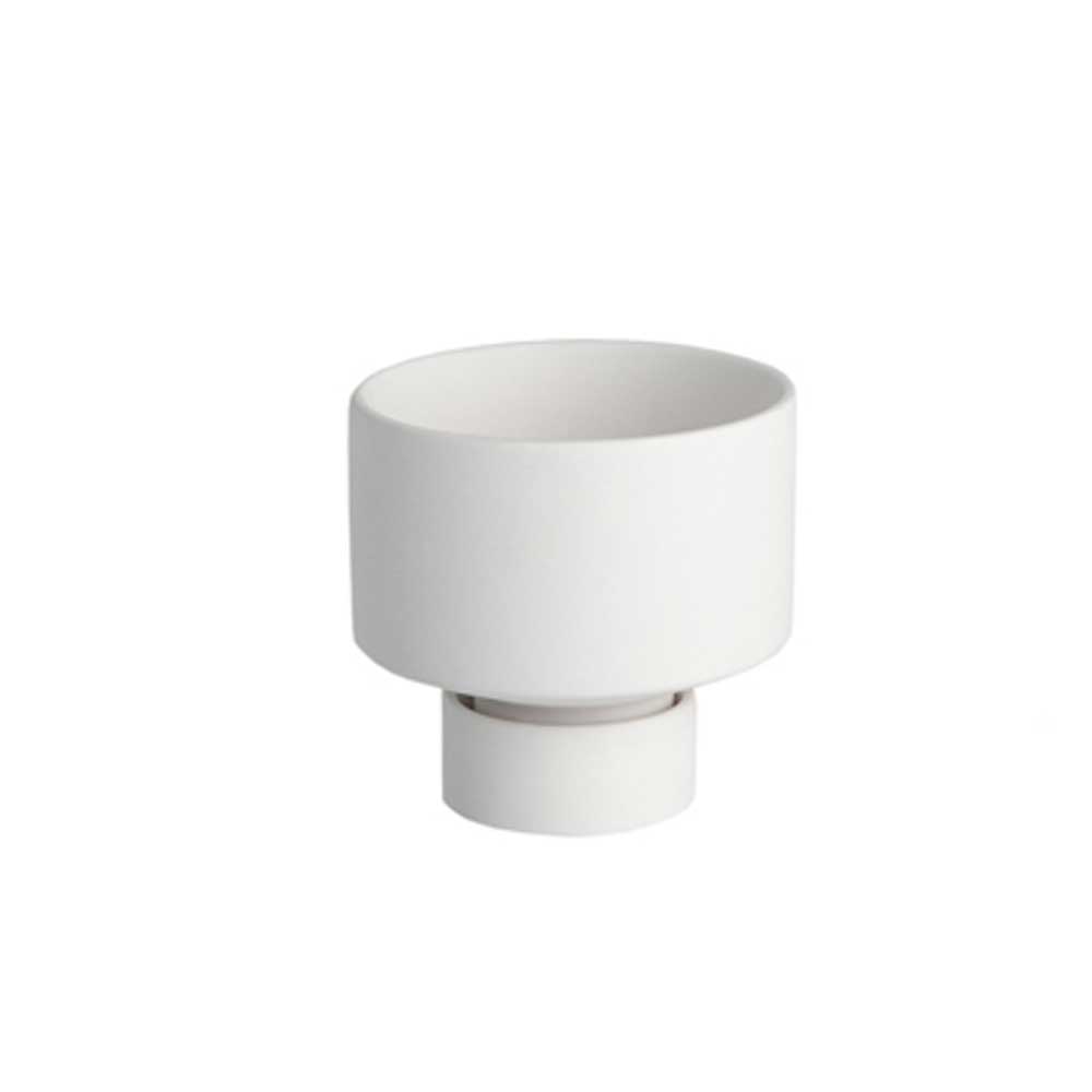 Ein kleiner Storefactory - Liaved Kerzenhalter für Stabkerzen und Teelicht weiß sitzt auf einer weißen Oberfläche.