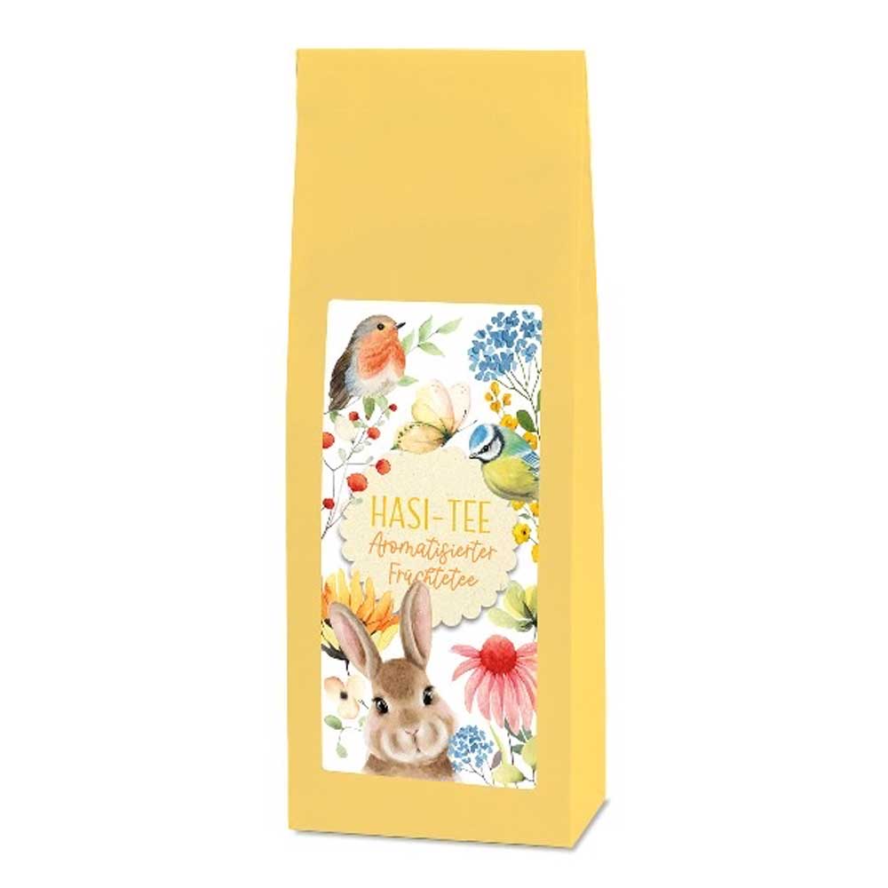 Eine gelbe Tee-Maass - Hasi Tee Früchtetee-Verpackung mit Illustrationen von Vögeln, einem Hasen und Blumen.